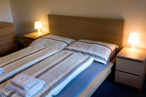 two beds in a room with two lamps and towels at Apartmány Na náměstí in Boží Dar