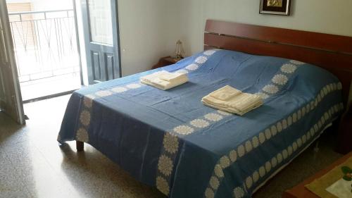 ランダッツォにあるCasa Vacanze Santa Caterinaのベッドルーム1室(ブルーベッド1台、タオル2枚付)
