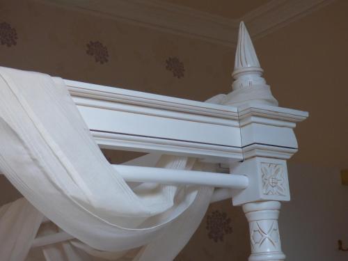 a white bed frame with white curtains on it at Douglas Park Guest House in Dunoon