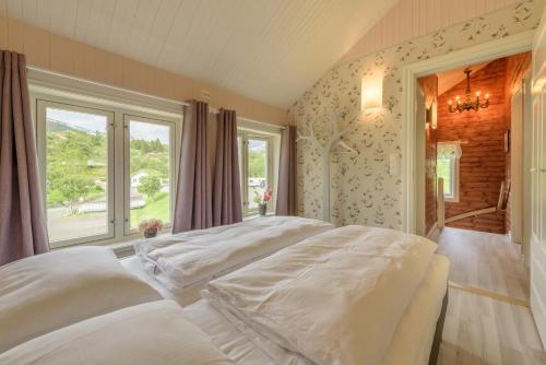 a large white bed in a room with a window at Kabelvåg Feriehus & Camping in Kabelvåg