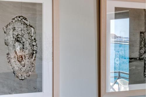 a picture on a wall next to a window at Naves Suites in Ermoupoli