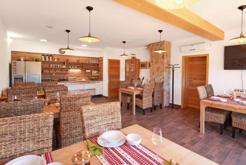 a dining room with tables and chairs and a kitchen at B&B Apartments Burić Plitvice Lakes in Seliste Dreznicko