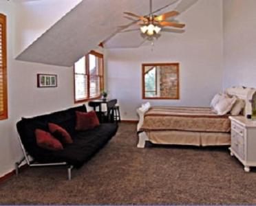 a bedroom with a bed and a couch and a ceiling fan at Zion Ponderosa Ranch Resort in Springdale
