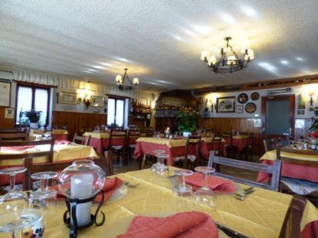 un comedor con mesas y sillas en un restaurante en Al Cavallino Bianco, en Tricesimo