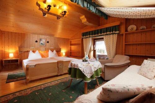 a bedroom with two beds and a table and a couch at Haus Dittrich in Kirchberg in Tirol