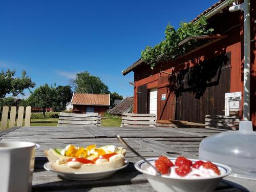 a wooden table with two bowls of fruit on it at Äventyrsgårdens Vandrarhem, Kinnekulle in Källby