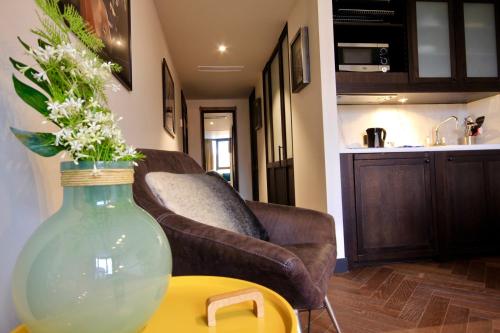 a vase with flowers on a table in a living room at Getaway Studios Brussels Airport in Zaventem