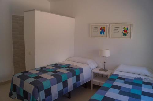 a small bedroom with two beds and a lamp at Beach-Front Bahia Dorada in Estepona