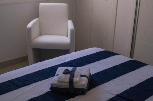 a room with a bed with a chair and a bag on it at Beach-Front Bahia Dorada in Estepona