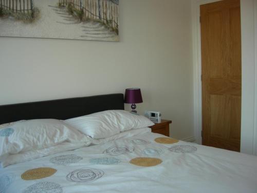 a bed with two pillows and a blanket on it at High Street Suites 3 in Ventnor