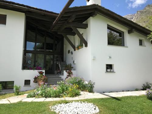a white house with flowers in front of it at Chesa Suot Ovas in Sils Maria