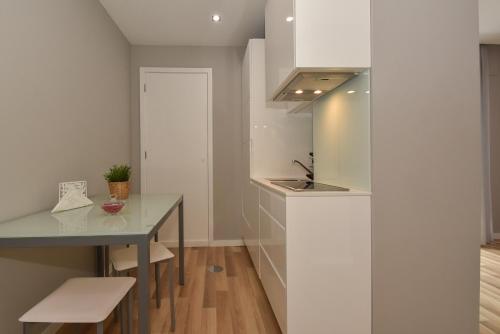- une cuisine avec un comptoir, une table et un évier dans l'établissement Oporto Bernardes Studios - Heroísmo, à Porto