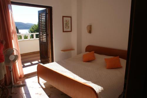 a bedroom with a bed with orange pillows on it at Villa Punta in Okrug Donji