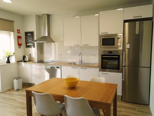 a kitchen with a wooden table and a refrigerator at Always Porto in Vila Nova de Gaia