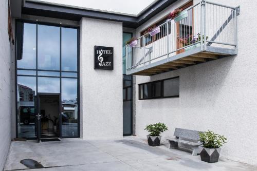 - un bâtiment avec un balcon et un banc devant dans l'établissement Hotel Jazz - By Keflavik Airport - Reykjavik - Iceland, à Keflavík