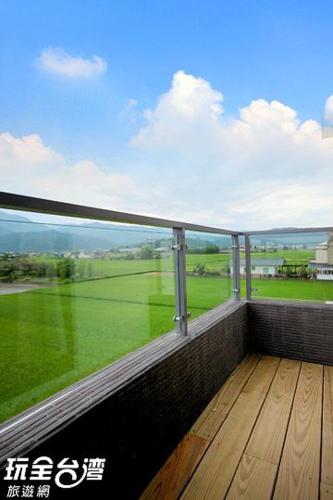 a balcony with a view of a green field at 宜人生活溜滑梯親子民宿 Easylife B&B in Dongshan