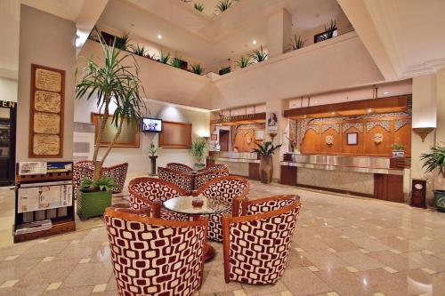 a lobby with chairs and a table in a building at The Jayakarta Suites Bandung in Bandung