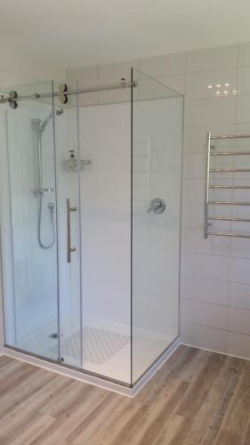 um chuveiro com uma porta de vidro na casa de banho em Jake's Place Oneroa Waiheke em Oneroa