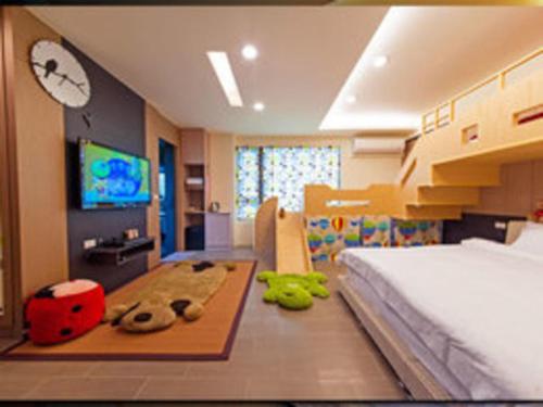 a bedroom with a bed and a tv on a wall at 宜人生活溜滑梯親子民宿 Easylife B&B in Dongshan