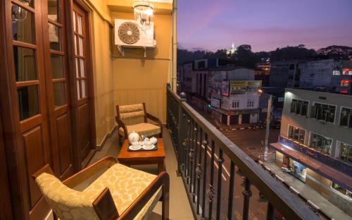 a kitchen area with a balcony overlooking a city at Ceyloni City Hotel in Kandy