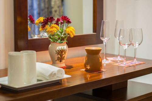 a table topped with a vase filled with flowers at Ceyloni City Hotel in Kandy