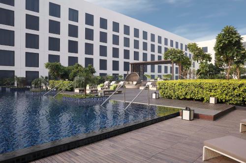 a rendering of the exterior of a building with a swimming pool at Novotel New Delhi Aerocity- International Airport in New Delhi