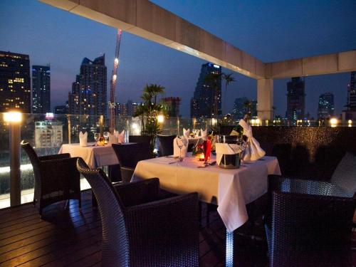 a restaurant with tables and chairs with a view of the city at I Residence Hotel Silom in Bangkok
