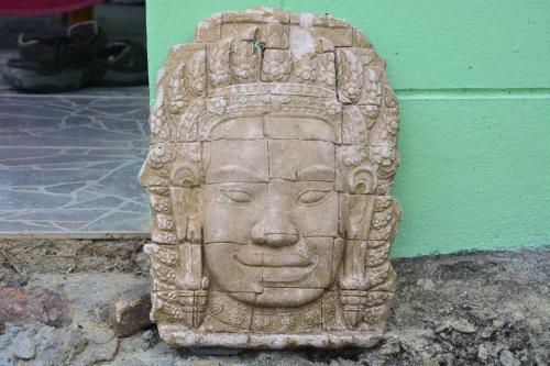 a stone statue of a head in front of a wall at TP Hut Bungalows in Ko Chang