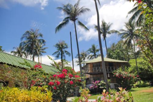 a resort with palm trees and flowers in a garden at TP Hut Bungalows in Ko Chang