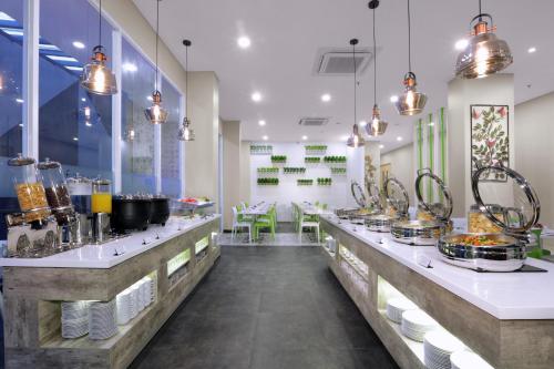 um restaurante com um balcão longo com panelas e frigideiras em favehotel Sorong em Sorong