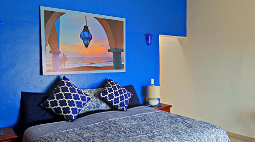 a blue bedroom with a bed with two pillows at Villa Star of the Sea in Barra de Navidad