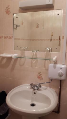 ein Badezimmer mit einem weißen Waschbecken und einem Spiegel in der Unterkunft Ty Llew in Llandysilio