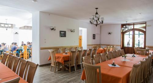 un comedor con mesas y sillas y gente comiendo en Hostel Teleki en Sovata