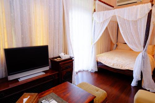 花蓮市的住宿－眠月樓民宿 ，一间带床和电视的客厅