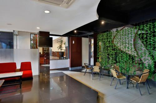 a restaurant with a green wall with chairs and a table at Jayakarta Hotel Jakarta in Jakarta