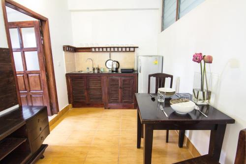 a kitchen with a table and a refrigerator at YK Art House in Phnom Penh
