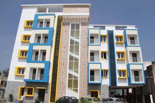 un edificio de apartamentos con ventanas azules y amarillas en Jeyam Residency, en Dindigul