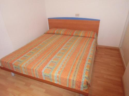 リニャーノ・サッビアドーロにあるRanch Sabbiadoroのウッドフロアの小さな部屋のベッド1台分です。