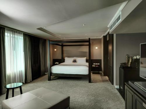 a hotel room with a bed and a couch at S15 Sukhumvit Hotel in Bangkok