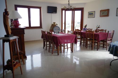 un comedor con mesas y sillas con mantel púrpura en B&B La Pineta, en SantʼAntìoco