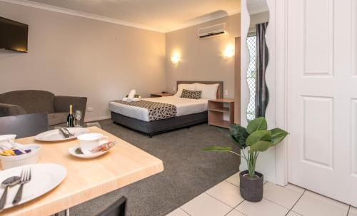 a hotel room with a bed and a table at Pacific Coast Motel in Gold Coast