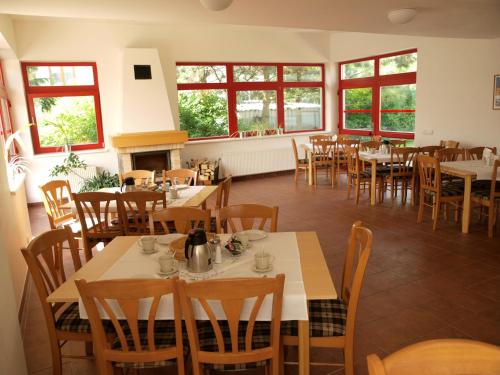 a dining room with tables and chairs and windows at Penzion Horinka Velké Losiny in Velké Losiny