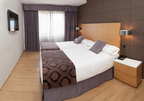 a hotel room with a bed and a dresser at Hotel Universal in Santiago de Compostela