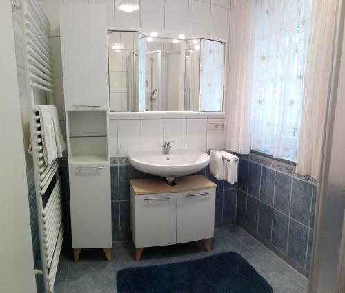 a bathroom with a sink and a mirror at Ferienwohnungen Erika Huber direkt an der Therme in Bad Birnbach