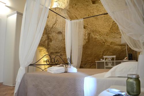 1 dormitorio con 2 camas con cortinas blancas en B&B Fontana La Stella, en Gravina in Puglia