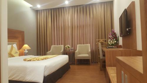 a hotel room with a bed and a desk at Sai Gon Kim Lien Hotel Vinh City in Vinh