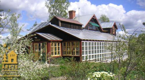 ein großes Haus mit einem Dach darüber in der Unterkunft STF Växhuset Hostel in Bodarne