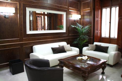 Sala de estar con 2 sofás blancos y mesa de centro en Hotel San Sebastián Hospedería en Cieza