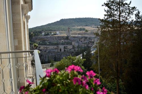 a balcony with pink flowers and a view of a city at B&B Fontana La Stella in Gravina in Puglia