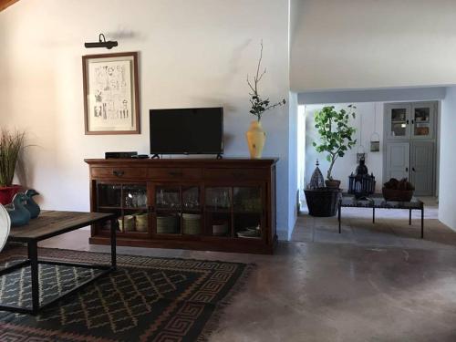 a living room with a tv on top of a cabinet at Monte de Sao Francisco in São Miguel de Machede